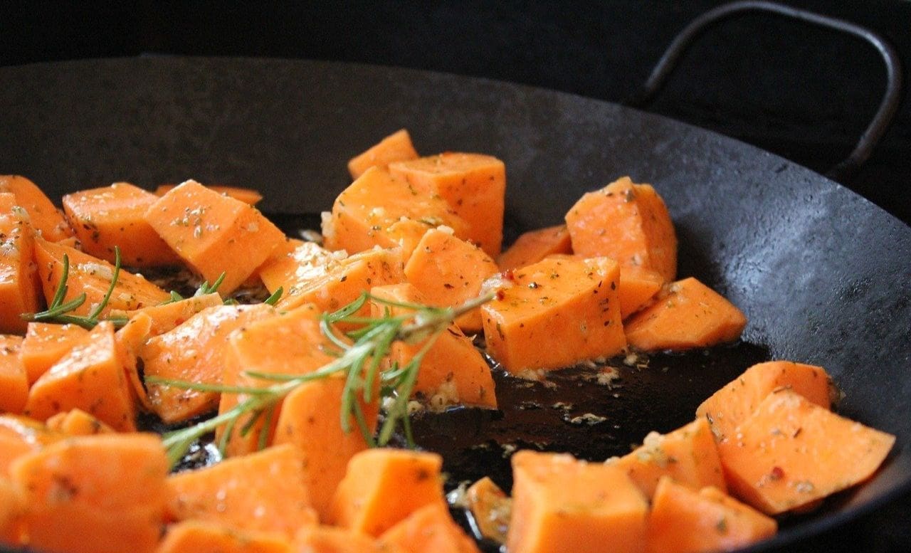 A pan of food with some cut up sweet potatoes.